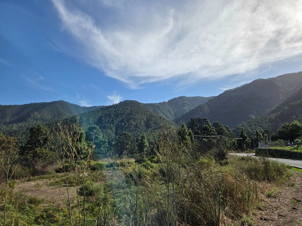 Blick auf grüne Berge bei Aguamansa unter einem weiten blauen Himmel mit auffälligen weißen Wolken.