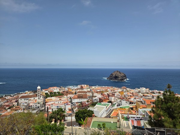 Panoramablick auf Garachico mit Kirche, roten Dächern und der Felseninsel Roque de Garachico im Atlantik.