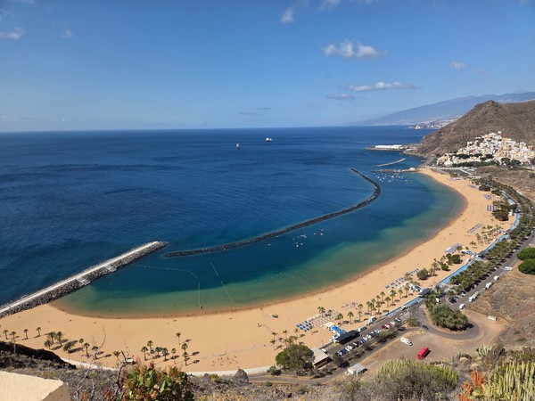 Aussicht auf die geschwungene Bucht von Las Teresitas mit goldenem Sand, Wellenbrechern und dem Ort San Andrés.